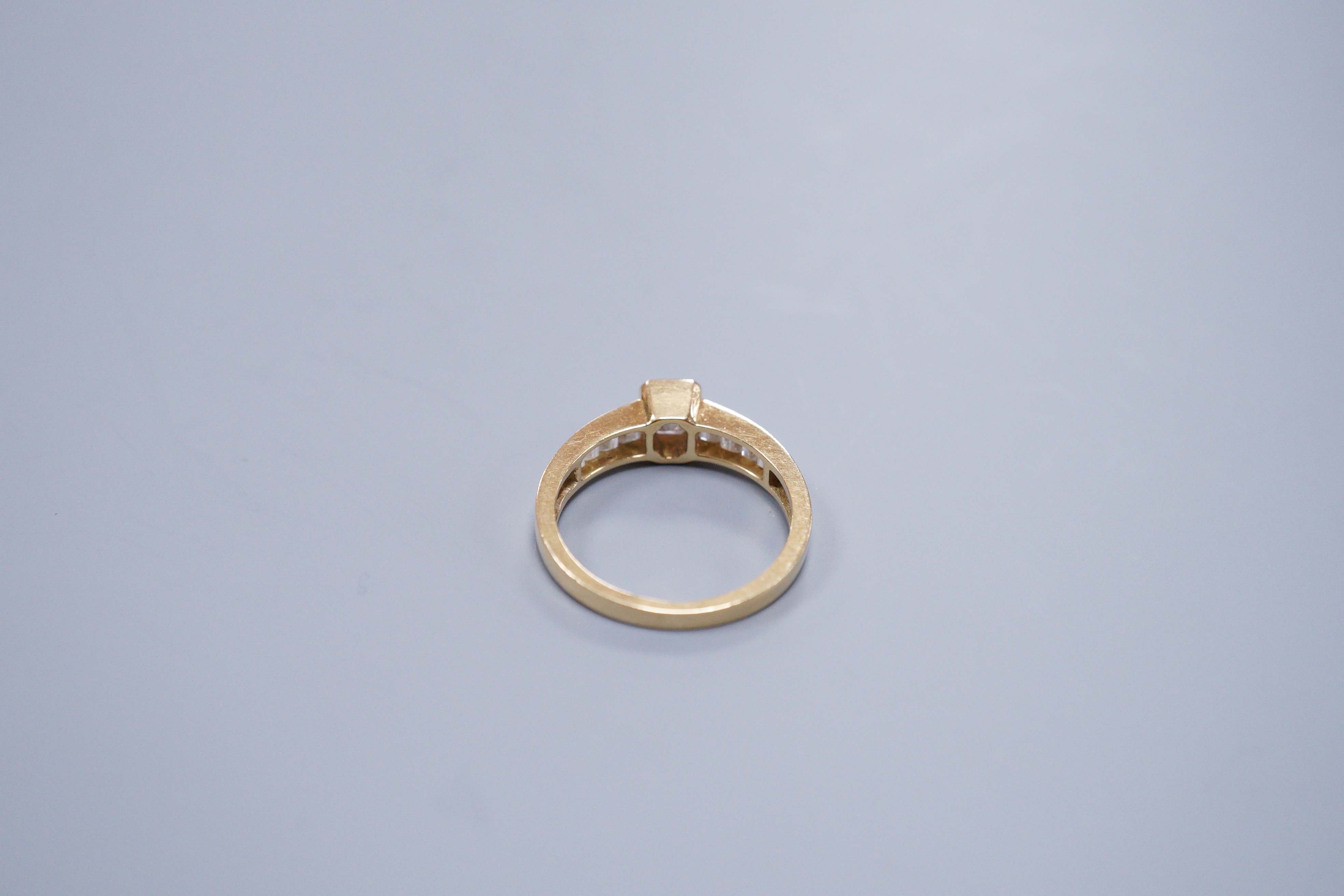 Am 18ct gold and diamond dress ring, with central octagonal cut stone and emerald cut shoulders, size O, gross weight 3.4 grams